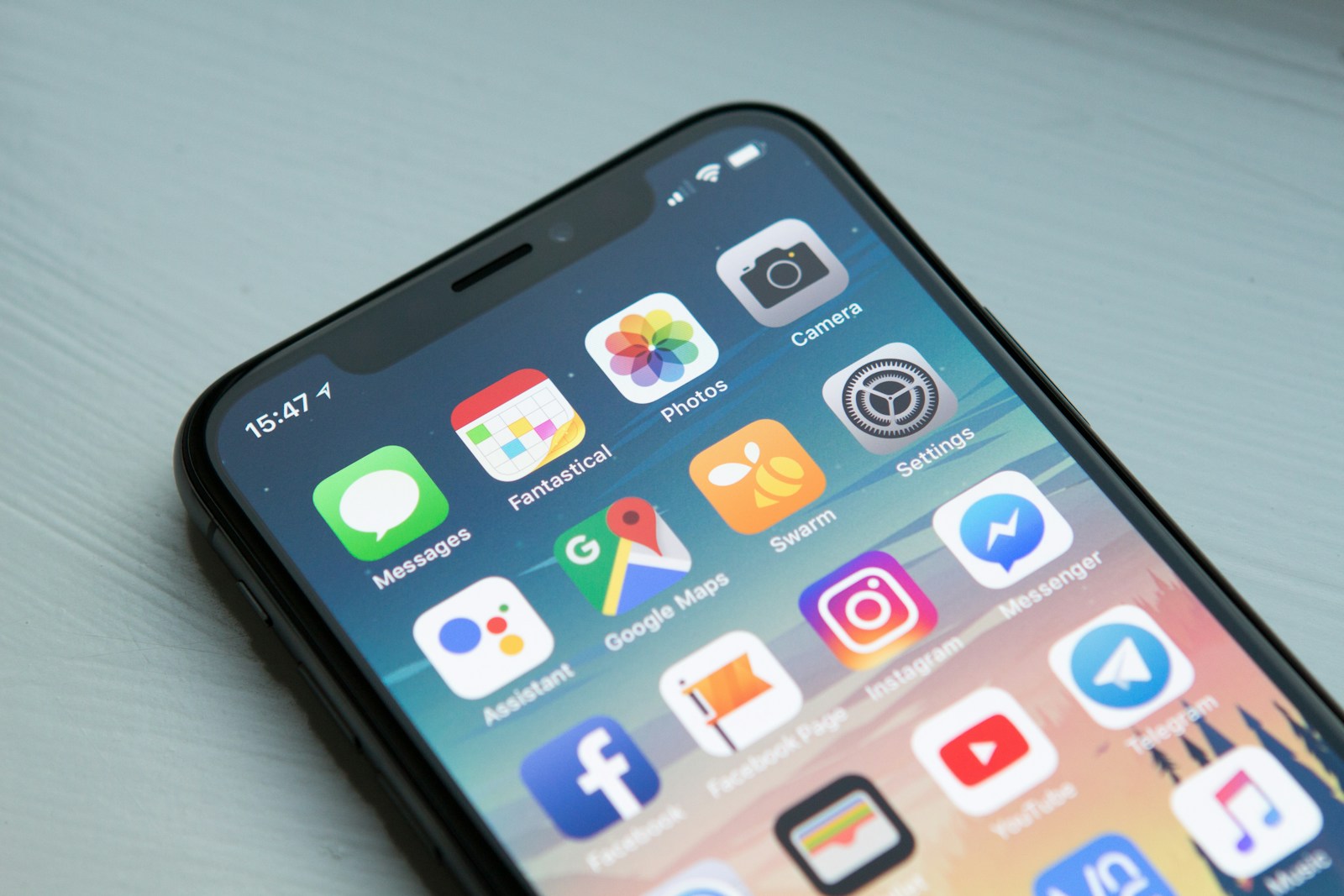 Space gray iPhone on a desk with the home screen visible
