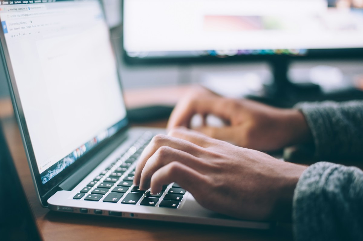 Person searching digital files on a laptop in an office.